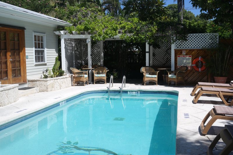Heated pool with pergola and wicker seating at Heron House Court