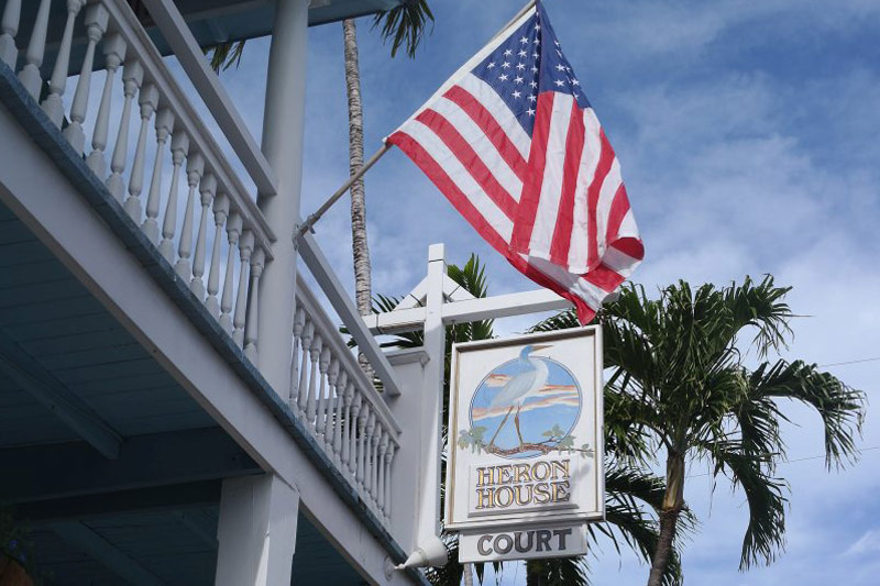 Heron House Court sign with American flag and palm tree