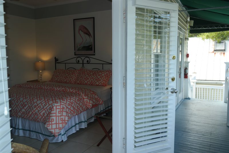 Spacious suite with sitting area, coral accents, and private balcony